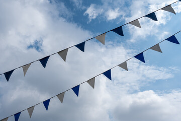triangle flags hanging in front of cloudy sky background