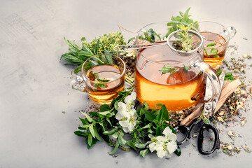 Herbal tea with cups and teapot on light gray backround.