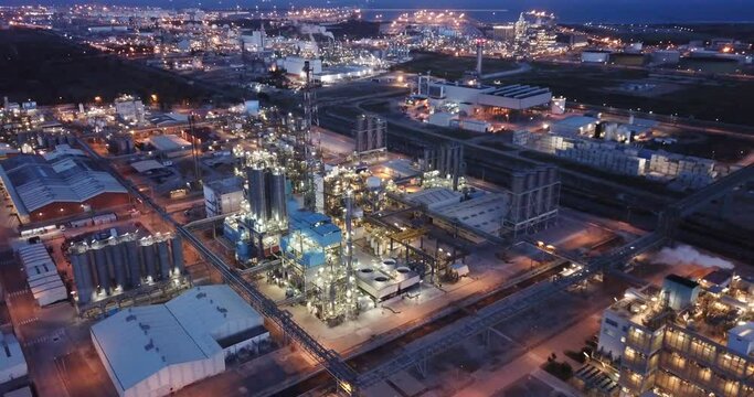 Aerial view of illuminated chemical process plant near Spanish town of Salou at twilight