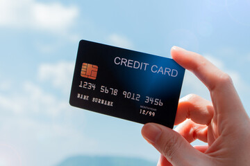 A woman showing a credit card, Travel Pay for trips and tours Airfare, the background is clear, blue sky and the sea in the daytime is sunny.