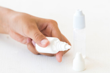 hand of girl holding lubricant eye drops for dryness and imitation teardrop of the eye with sterilize eye drops medicine for eye on background white 
