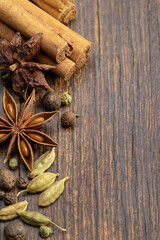 Close-up top view of various spices. A set of spices, cooking seasonings, anise, cardamom, cinnamon, allspice peas. Spectacular brown background.