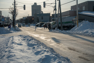 市街地の凍結した道路を走る車  北海道札幌市の日常生活イメージ