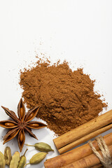 Cinnamon rolls and slide of ground cinnamon, cardamom, anise on  white background, studio shot, copy space.