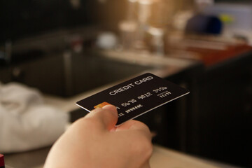 coffee shop cafe, a female customer handed over a credit card. To pay for food, beverages, tea, and coffee At the bar counter