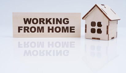 There is a wooden house and a sign on the table - Working from home