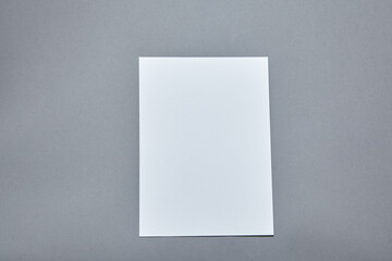 Lavender blossom with white paper sheet mockup on gray background. White paper empty blank, dried flowers on gray table. Invitation card mockup.Flat lay, top view, copy space, mockup