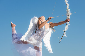 Sexy sensual angel with bow and arrow. Cupid girl in white dress. Portrait of sweet angelic girl....