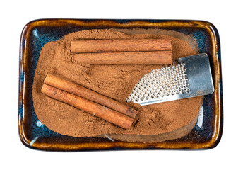 cassia, grater and cinnamon powder in bowl cutout