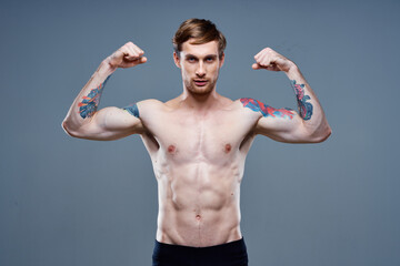 strong male athlete with pumped up arm muscles and tattoo bodybuilder fitness