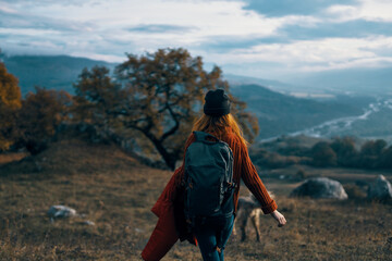 Fototapeta premium woman hiker with backpack on nature landscape dog