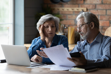 Concerned elderly couple discuss unpaid bank debt, calculate expenses feels troubled due lack of money to pay household bills, experiencing financial problems, house eviction notice, crisis concept