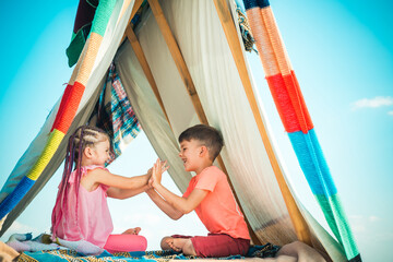 Children couple playing in tent. Camping. Summer outdoor activity. Happy childhood concept. Cute kids.