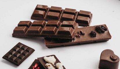 Milk chocolate pieces isolated on white background from top view