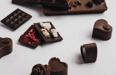 Milk chocolate pieces isolated on white background from top view