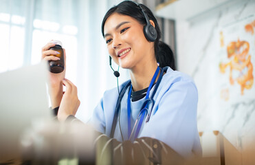 Portrait of young asian woman doctor with white coat standing in hospital.Telemedicine, Medical online, e health concept. Doctor using laptop for work.Remote medical help for distance patient advice.