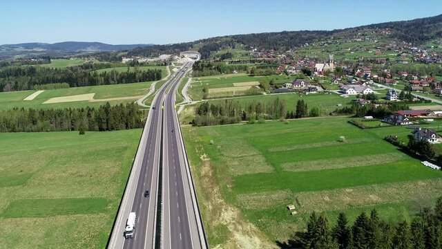 New highway in Poland on national road no 7, E77, called Zakopianka.  Skomielna  Biała village and the old road on the right. Far view of a tunnel under construction. Aerial 4K video
