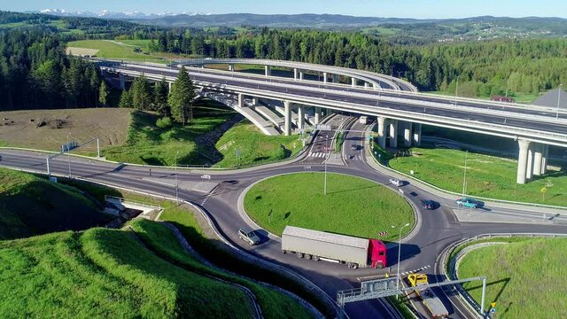 New highway in Poland on national road no 7, E77, called Zakopianka.  Overpass junction with a traffic circle, viaducts, slip roads, cars near Skomielna Biala. Aerial view. Far view of Tatra Mountains