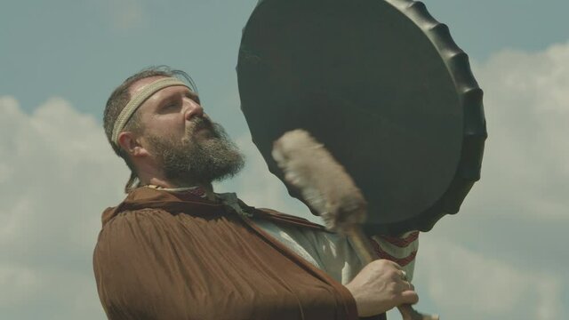 a schuman man plays a shamanic drum, tries to make it rain, worship the old gods and nature. the meaning of the shaman in nature , prores 422, bmpcc4k