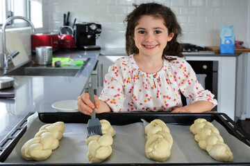 Cute Jewish girl baking sweet Challah bread for Sabbath Jewish Holiday