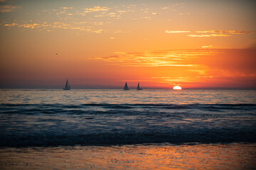 Fototapeta na wymiar Sailboat at sea. Sunrise over the sea and beautiful cloudscape. Colorful ocean beach sunset.