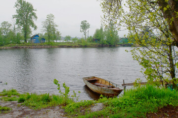 Obraz premium Fisherman boat is moored on the water near the shore. Fishing of Northern peoples. 