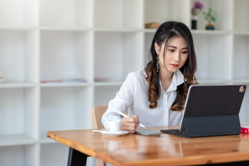 Young businesswoman sitting at the office using a tablet and smartphone put at office.