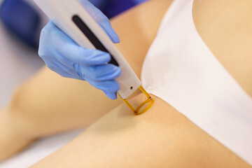 Woman receiving groins laser hair removal at a beauty center. - obrazy, fototapety, plakaty