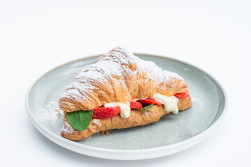 croissant stuffed with cheese cream and fresh strawberries. croissant sandwich with mascarpone cream and strawberry