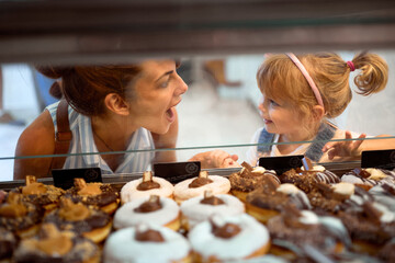 Mother and daughter buying yummy donuts together