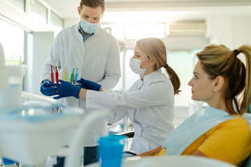 The dentist and her assistant prepare to show patient how to brush teeth properly.