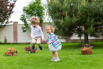 Happy children jump up, green grass. Sweet Childhood.