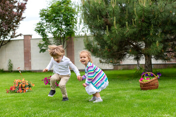 Happy children jump up in the green grass. Sweet childhood