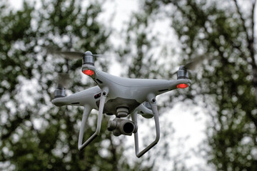 A white drone quadcopter taking off from the ground. Soft focus. Motion blur.