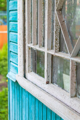 A small window with white paint falling off on the frame in an old rustic wooden house