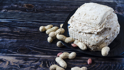 Peanut halva with nuts on a dark wooden background top view. Halva oriental sweets	