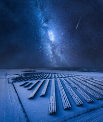 Milky way over photovoltaic farm. Alternative energy in winter, Poland.