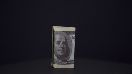 American dollars. Rolled up banknote. Money on a black background. Profit. from business. Sale. The...
