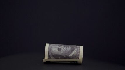 American dollars. Rolled up banknote. Money on a black background. Profit. from business. Sale. The cost of goods. Money machine. Business income. Investing in your business. Finance. Close-up.