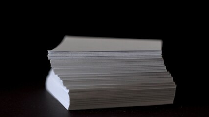 A stack of white note paper. Rotation of the paper. White sheets for notes. Stationery. Black...