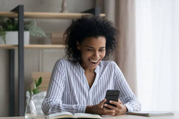 Overjoyed millennial African American woman feel euphoric with online lottery victory or win on...