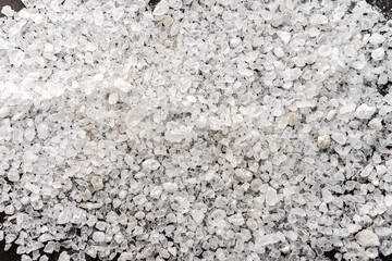 selective focus. food background. coarse sea salt in crystals. white color, stone. top view, with deep shadows. texture. macro, copyspace