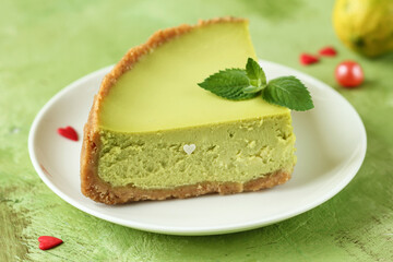 Сlose-up of  homemade freshly baked  lemon cheesecake against green background, dessert concept, selective focus.
