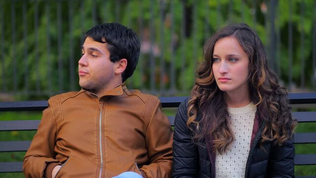 distant couple - young couple at park who have nothing more to say to each other