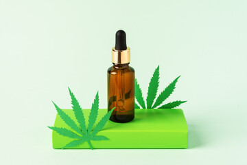 Cannabis oil extract in droplet bottle on green background. Medical marijuana cbd oil.