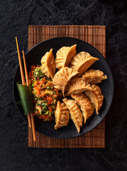 Asian Gyoza dumplings with pork meat and vegetables on a black background. Top view - 436458773