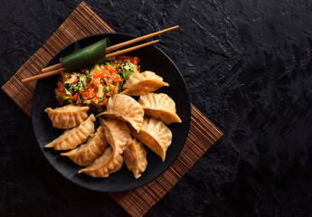 Asian Gyoza dumplings with pork meat and vegetables on a black background. Top view. Copy Space - 436458787