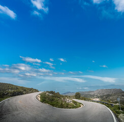U-shape mountain road under clear blue sky