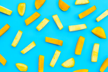 Pieces of mango on blue background.