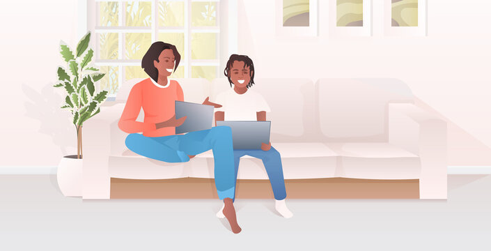 mother with daughter using laptops african american family spending time together